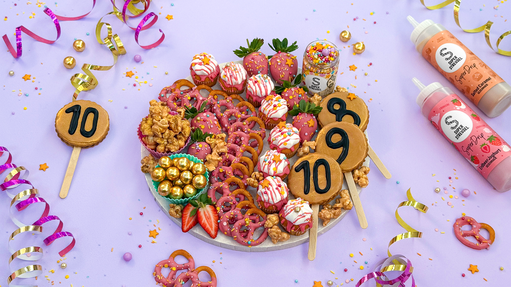 Snackboard mit verschiedenen süßen verzierten Gebäckstücken.